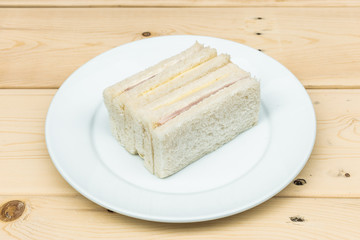 sandwiches on white plate and wooden plank