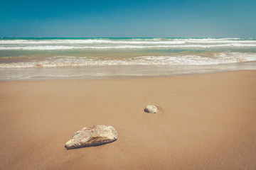 Fototapeta na wymiar Sandy beach on the shore of the calm turquoise sea with blue sky, island of Crete in Greece, Europe.