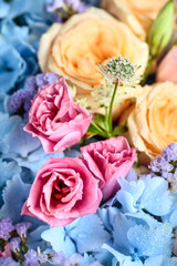 Close up of beautiful soft colour flower bouquet with blue Hydrangea, peach roses, pink lisianthus, ping pong mums and astrantia. Vertical composition