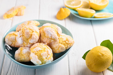 Cracked Lemon cookies in blue plates on white background