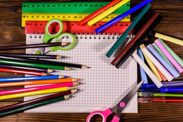 Different school stationeries on a dark wooden table. Top view