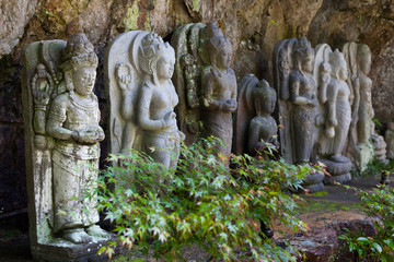 Line of stone statues at Mitaki Dera a temple in a forested valley near Hiroshima, Japan