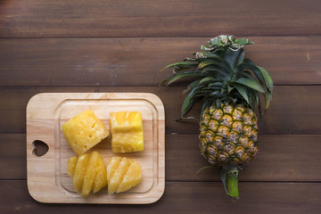 Pineapple is placed on wooden floor