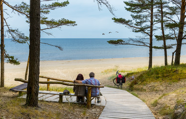 Happy couple of seniors are resting near a shore of the Baltic Sea, Jurmala, Latvia
