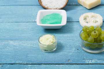 beauty product samples from grape seed ingredient, blue wooden table background, soft light