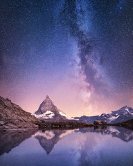 Matterhorn and reflection on the water surface at the night time. Milky way above Matterhorn, Switzerland. Beautiful natural landscape in the Switzerland