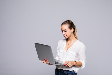 Portrait of confident intelligent woman using modern laptop for working isolated on gray background