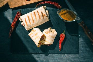 Traditional Mexican vegetarian burrito on a serving board close-up, top view