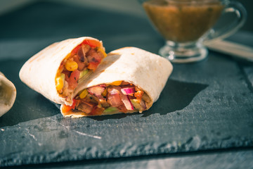 Traditional Mexican burrito on a serving board closeup