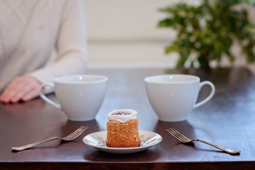 Waiting for someone in a caf'e on a table for 2: Runeberg's cake or tart is a Finnish traditional dessert and pastry