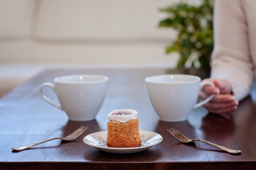 Waiting for someone in a caf'e on a table for 2: Runeberg's cake or tart is a Finnish traditional dessert and pastry