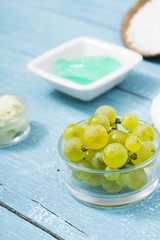 beauty product samples from grape seed ingredient, blue wooden table background, soft light