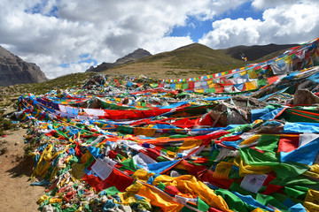 Tibet. Buddhist ritual flags with mantras and ritual drawings on the trail from the town of Dorchen...