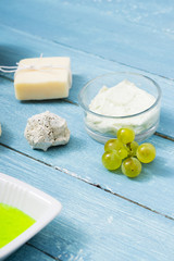 beauty product samples from grape seed ingredient, blue wooden table background, soft light