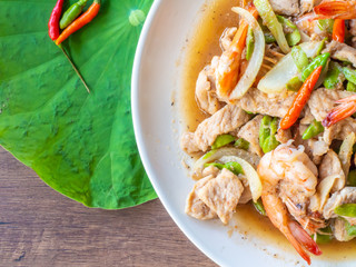 Thai food,Stir-Fried Twisted Cluster Bean with Shrimps and pork /Bitter Bean in white plate on wooden background.