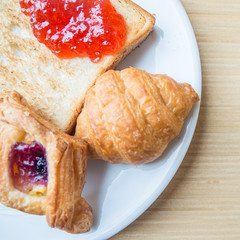 Bakery Bread,Croissant on a white plant. Various Bread and Sheaf of Wheat Ears Still-life.