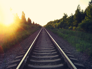 Fototapeta na wymiar Rail Road at Sunset Summer Beautiful Landscape with Empty Sky. Train Rail Track Perspective View with Sleepers on Rural Countryside Village Background with Sun Light Glow on Summer Day with No People