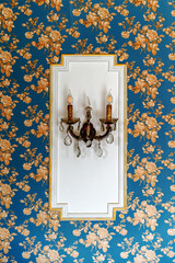 An antique chandelier on the wall with electric lamps