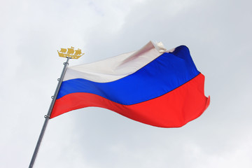Flag of Russia Isolated on Cloudy Sky Background. National Flag of Russia, Country Symbol View on Gloomy Weather. Russian Flag of White, Blue and Red Color on Mast Waving on Empty Sky Background.