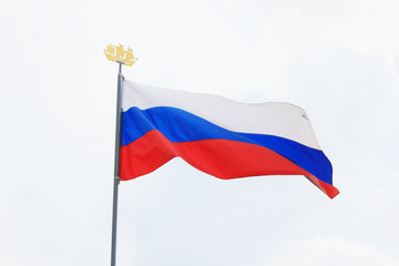 Russian Flag Isolated on Light Empty Sky Background on Sunny Bright Day. National Flag of Russia, Country Symbol View. Flag of White, Blue and Red Color Flutters on Empty Sky Background.