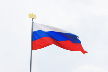 Russian Flag Isolated on Light Blue and White Sky Background on Sunny Bright Day. National Flag of Russia, Country Symbol View. Flag of White, Blue and Red Color Flutters on Empty Sky Background