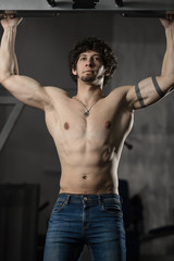 Obraz na płótnie Canvas Man in gym making Pull-up. Bodybuilder training in gym