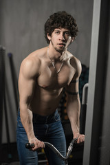 Fototapeta na wymiar Athletic muscular man training biceps in the gym