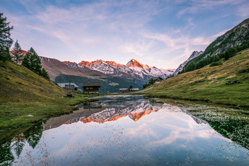 Crimson Sunset over Dent-Blanche Snowy Mountain Reflecting in Arbey Lake in Valais.