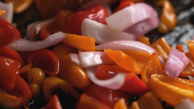 Stir frying onion and orange and red bell pepper. Shot with high speed camera, phantom flex 4K. Slow Motion.