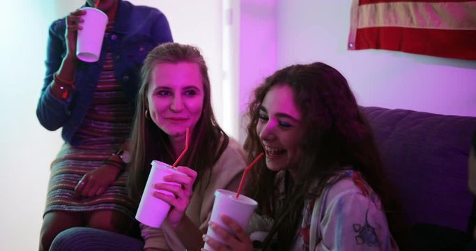 Multi-ethnic teenage friends toasting with soda at house party