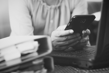 Hands of woman using mobile phone for payments online shopping. Black and white photo.