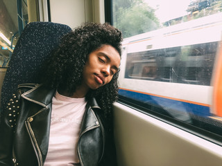 Tired black woman sleeping on the train