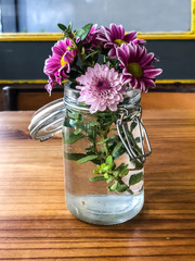 colorful daisies in jar over table
