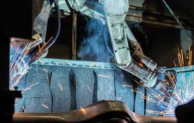 Team industrial robot are welding in factory