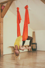 Woman doing aerial yoga in the fitness studio.