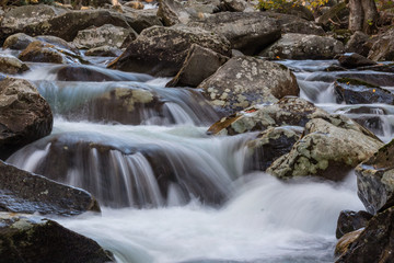 Multiple cascades of water across lichen covered rocks in the Great Smoky Mountains, horizontal aspect
