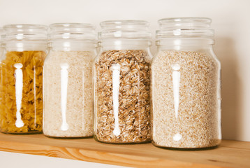 Various uncooked cereals, grains, pasta, bukwheat, rice, oat meals. Healthy cooking in glass jars...