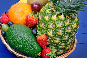 Healthy fresh fruits in a basket on wooden table