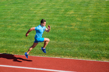Obraz premium Runner focused on result. Short distance running challenge. Boost speed. Athlete run track grass background. Run into shape. Sprinter training at stadium track. Running challenge for beginners