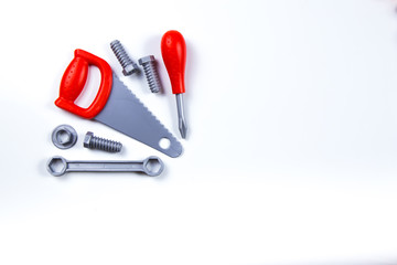 Kids construction toys tools: colorful screwdrivers, screws and nuts on wooden background. Top view. Flat lay. Copy space for text