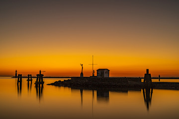 Fototapeta na wymiar Harbor entrance at sunset and in the background is a lighthouse