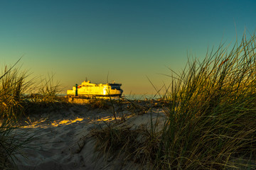 Fototapeta premium a car ferry on entering the harbor at beautiful sunrise