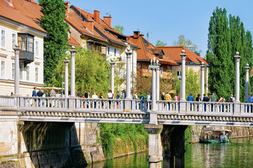 People on Triple Bridge and Ljubljanica River in Ljubljana