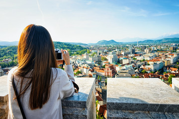 Fototapeta na wymiar Girl taking photos of panoramic view of Ljubljana Slovenia