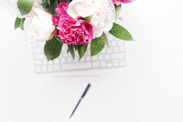 Workplace with keyboard pen pink white peonies