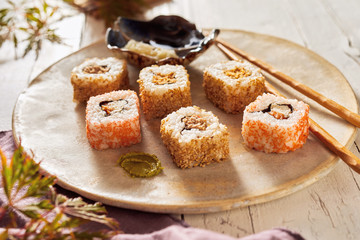 Uramaki sushi rolls on a rustic pottery plate