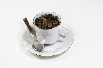 Portrait of a white cup of coffee full of coffee beans on a white background. Concept: Flaver, relax, drink