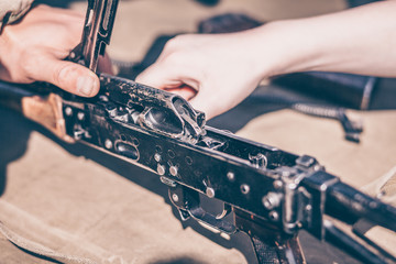 The boy performs disassembly, cleaning and assembly of AK-47, an automatic rifle Kalashnikov