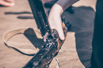 The boy performs disassembly, cleaning and assembly of AK-47, an automatic rifle Kalashnikov