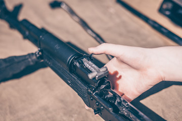 The boy performs disassembly, cleaning and assembly of AK-47, an automatic rifle Kalashnikov